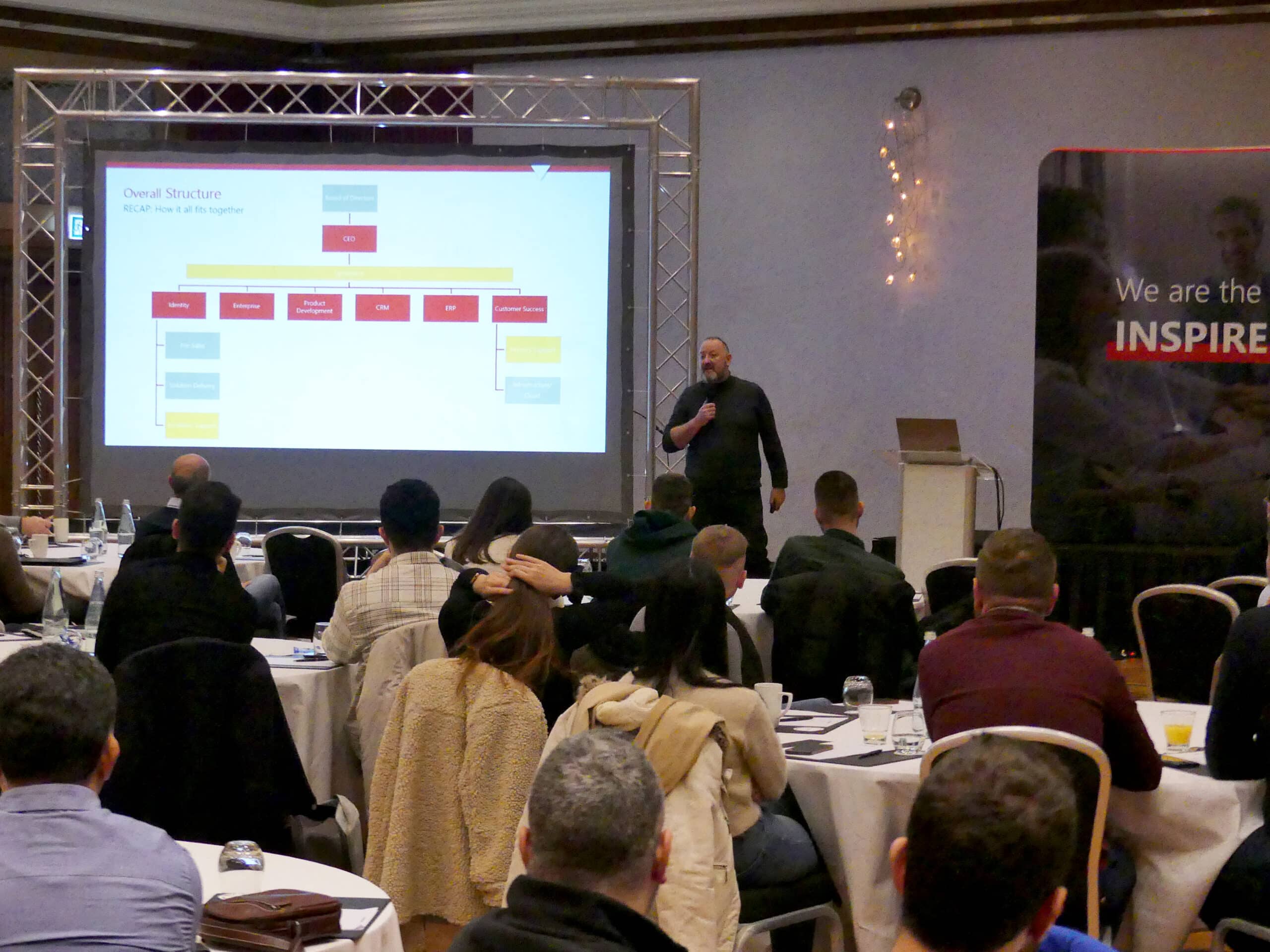 Speaker presenting company structure at Exigy internal event.