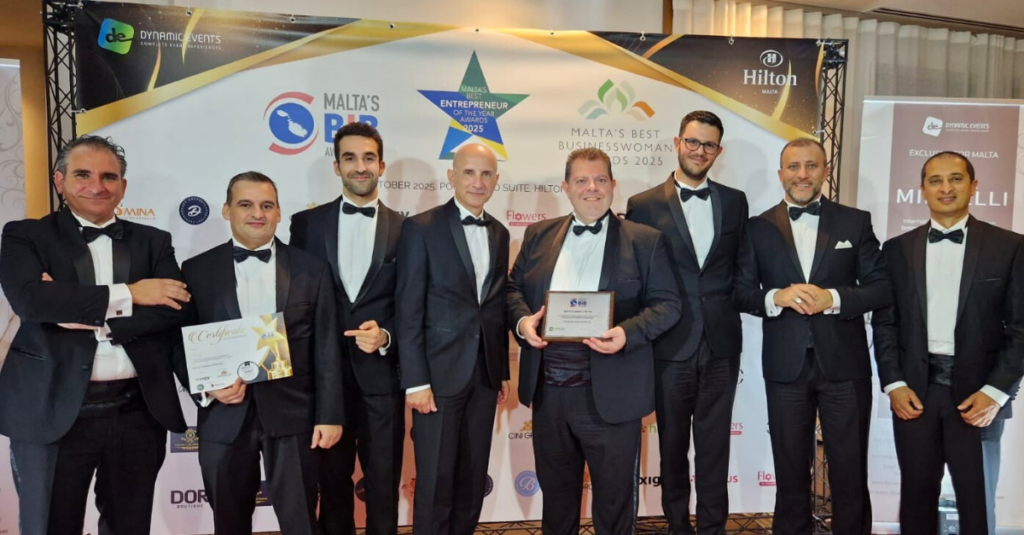 A group of Exigy team members in tuxedos posing with their award for Best ICT Company at the Best in Business Awards 2025, held at Hilton Malta.